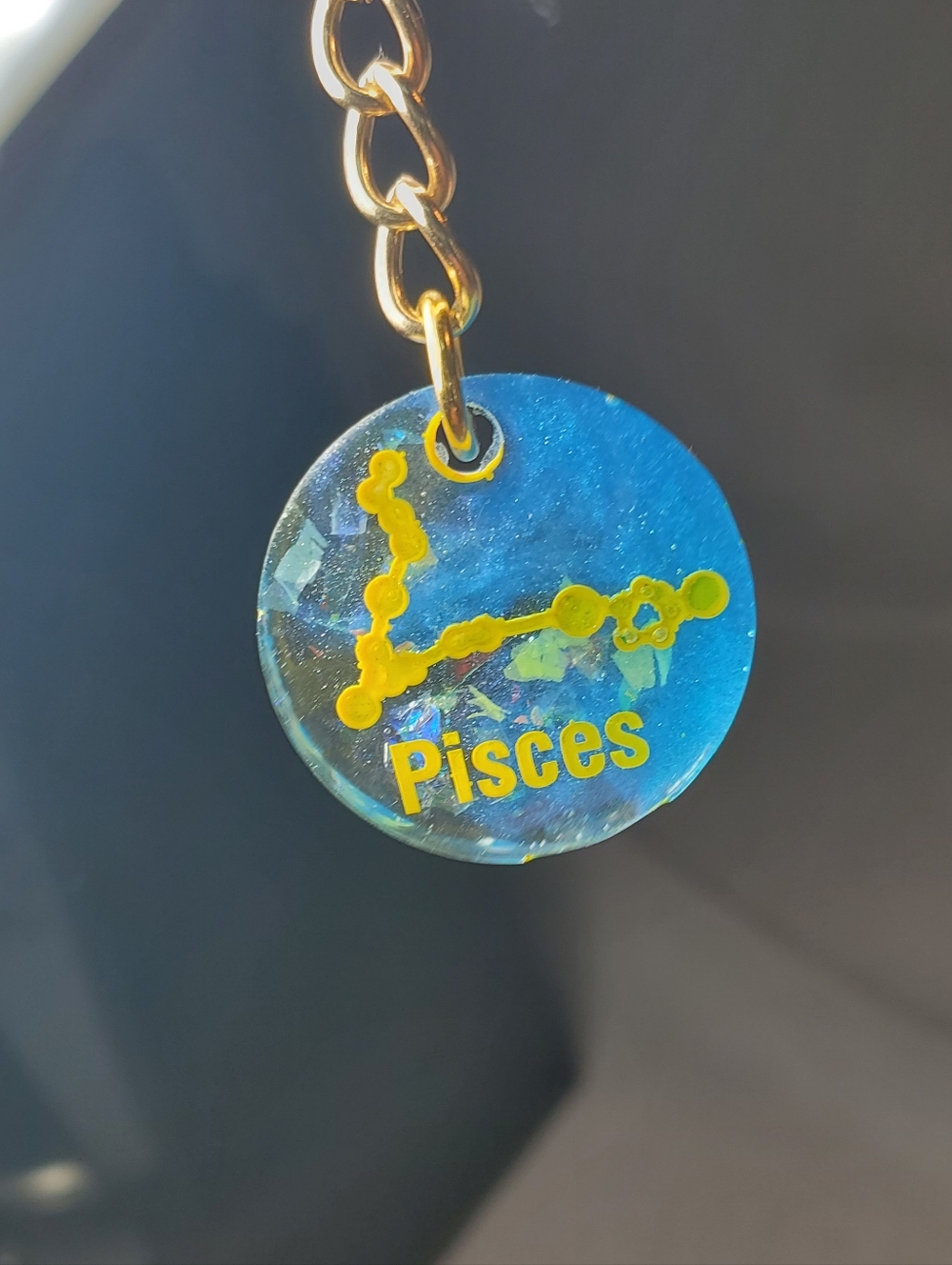 Pisces zodiac sign keychain, often featuring glitter, constellation designs